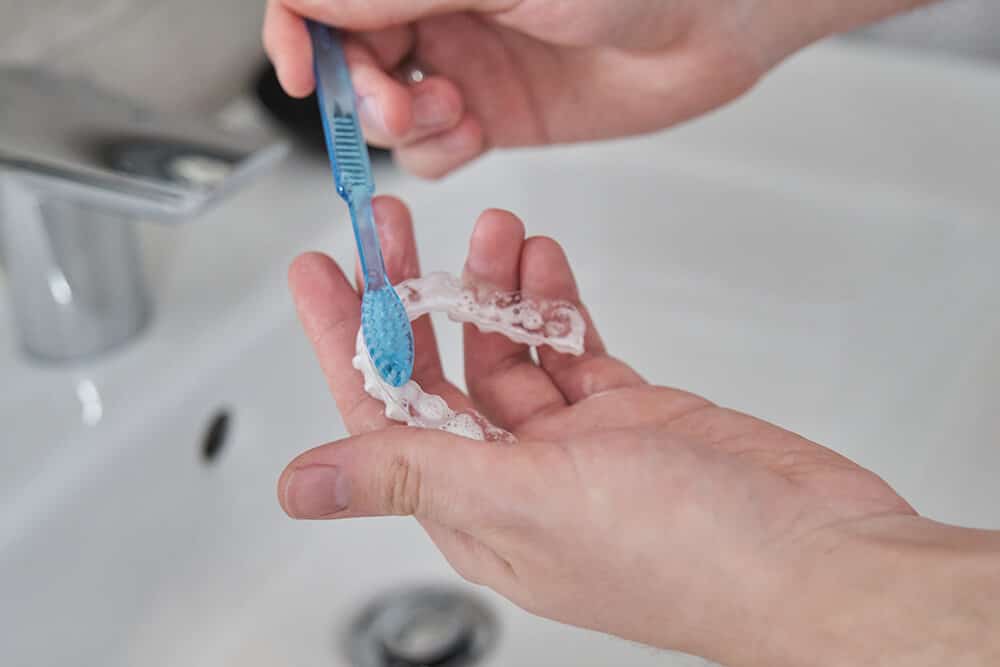 cleaning a clear aligner with a toothbrush